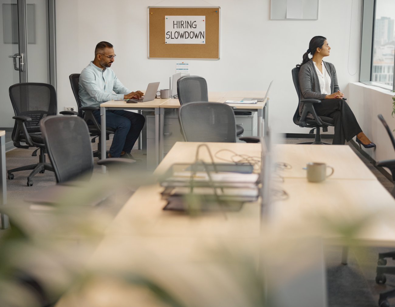 office workers empty desks hiring slowdown economy